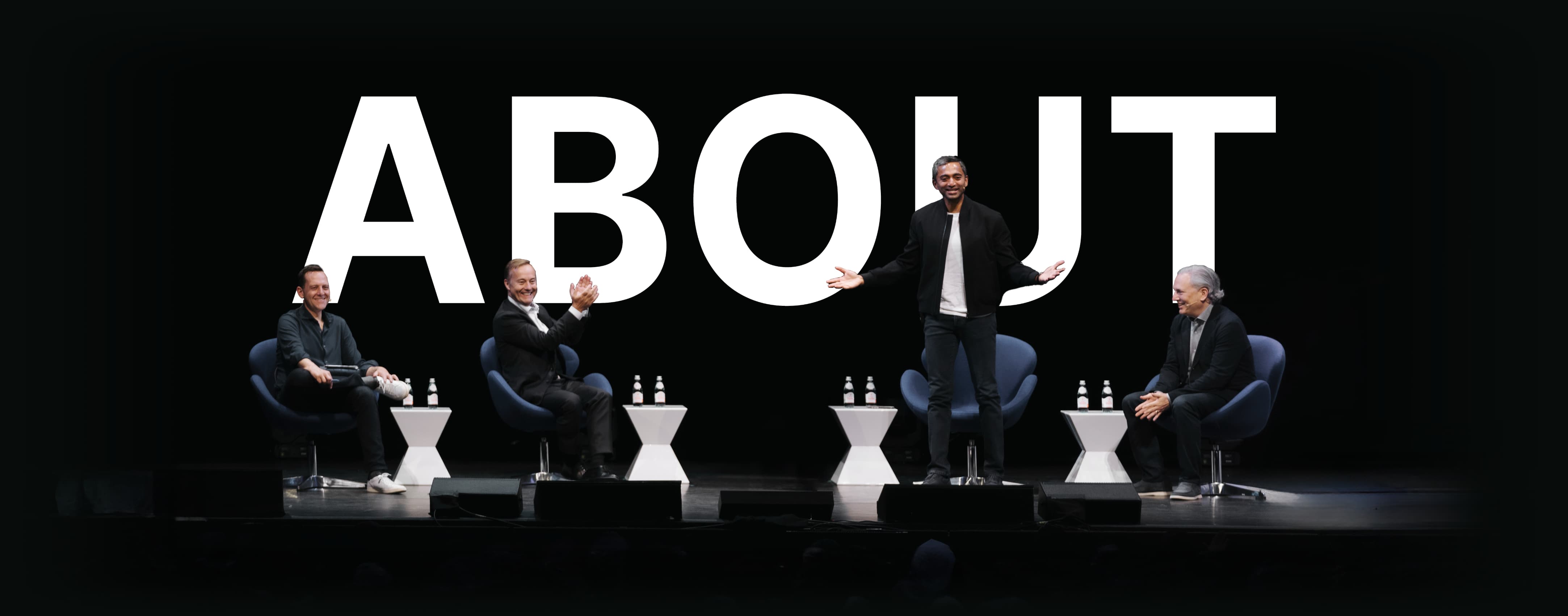 The four All-In hosts on stage, with Chamath Palihapitiya standing