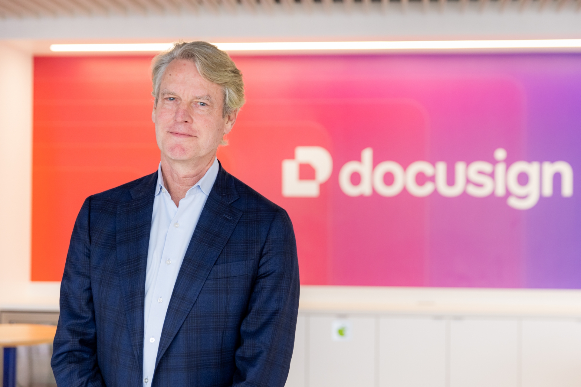 Allan Thygesen standing in front of a colourful Docusign sign