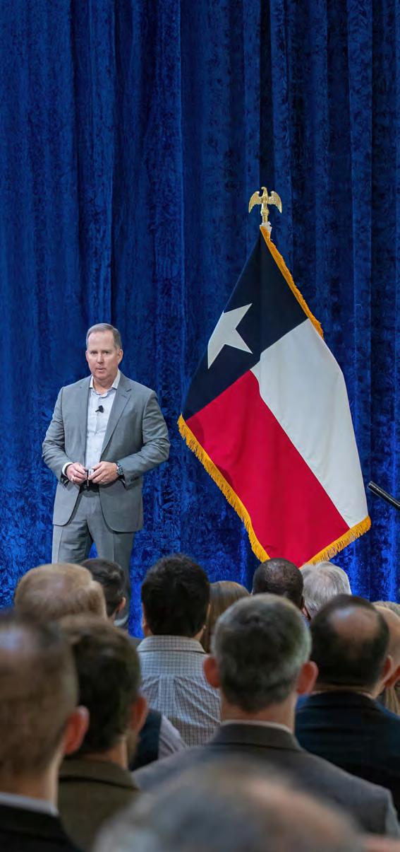 Allen Nye speaking to a seated audience beside a Texas flag at Oncor Strategy Day 2025