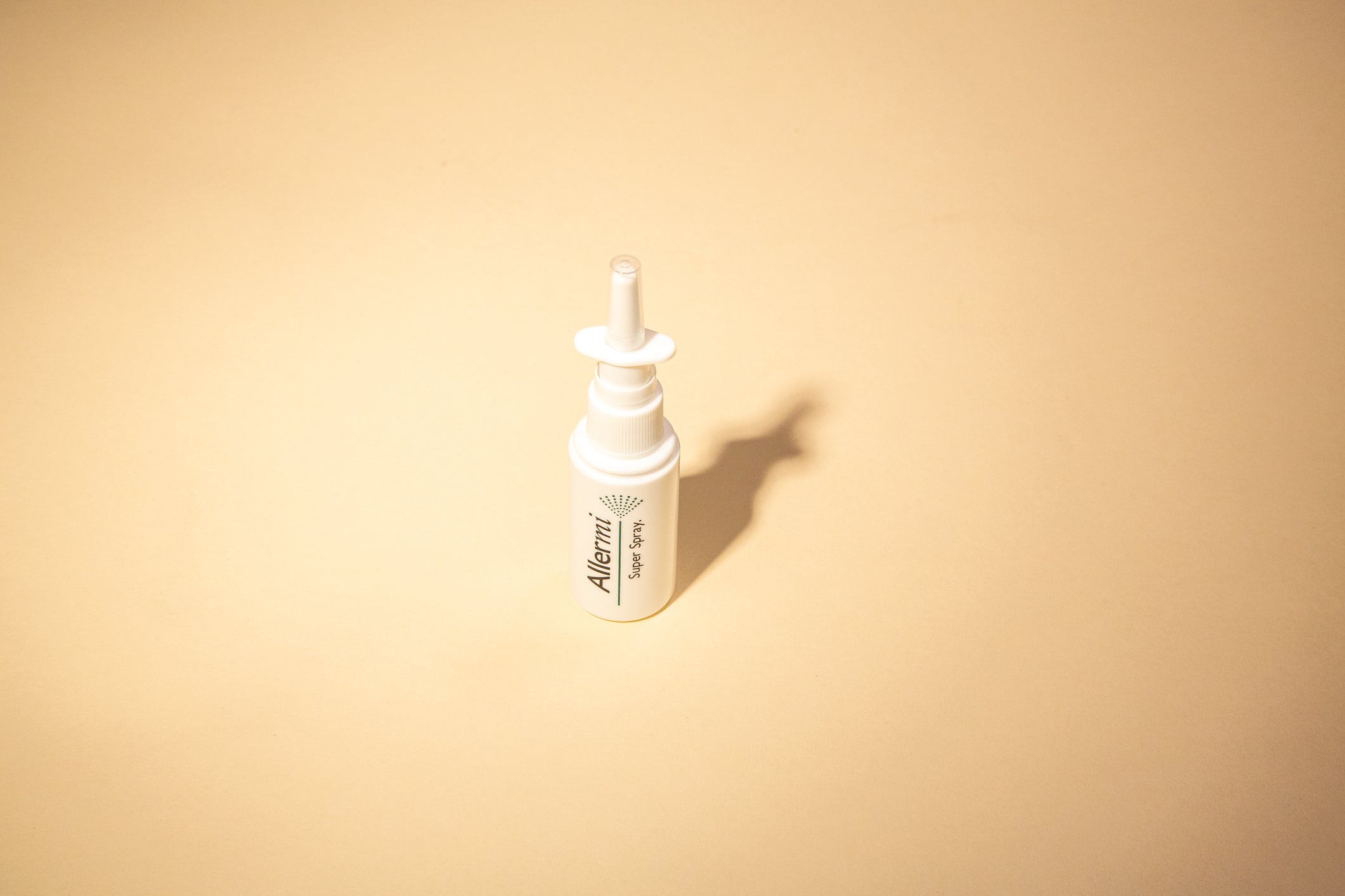 An Allermi Super Spray bottle against a warm beige background