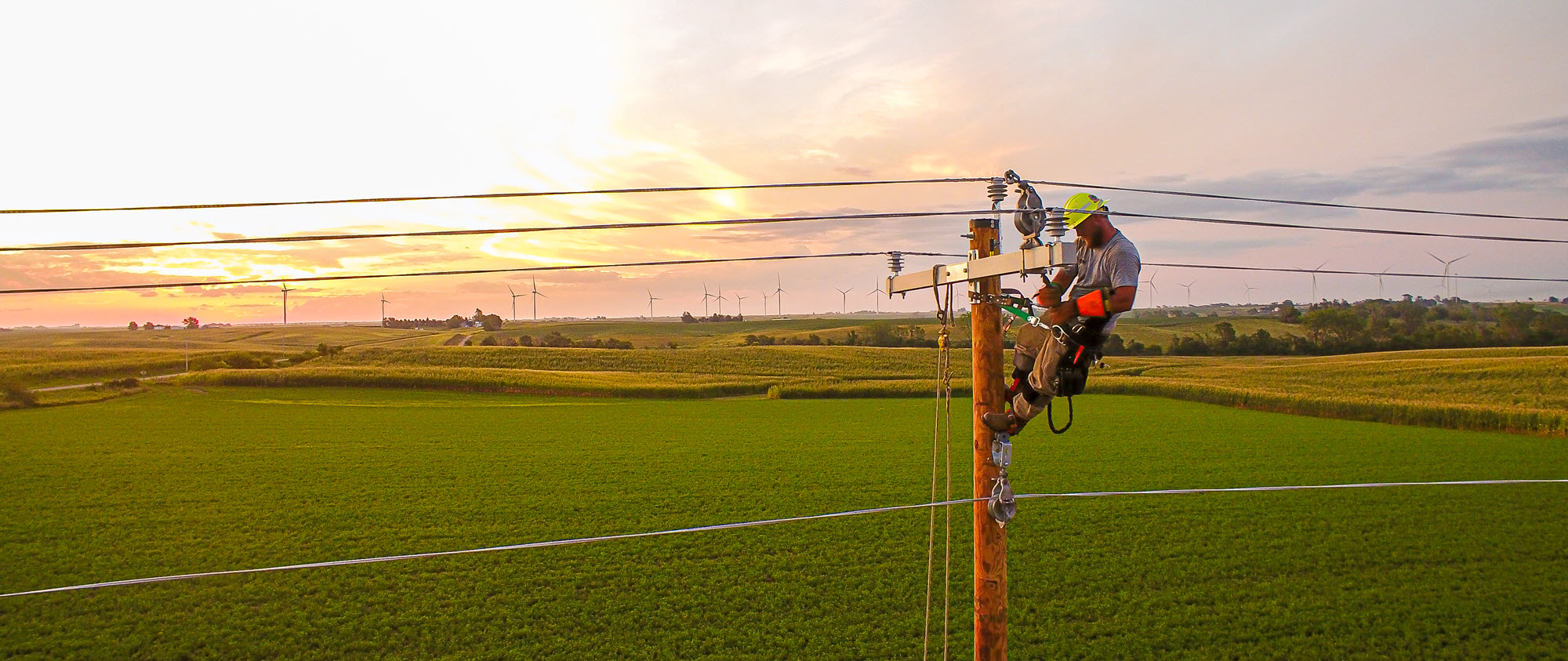 Alliant Energy line technician working high on a utility pole