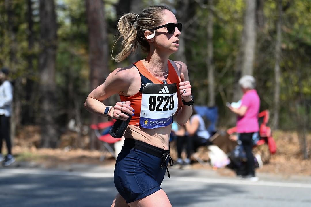 Allie Egan running a road race, wearing sunglasses and race bib 9229