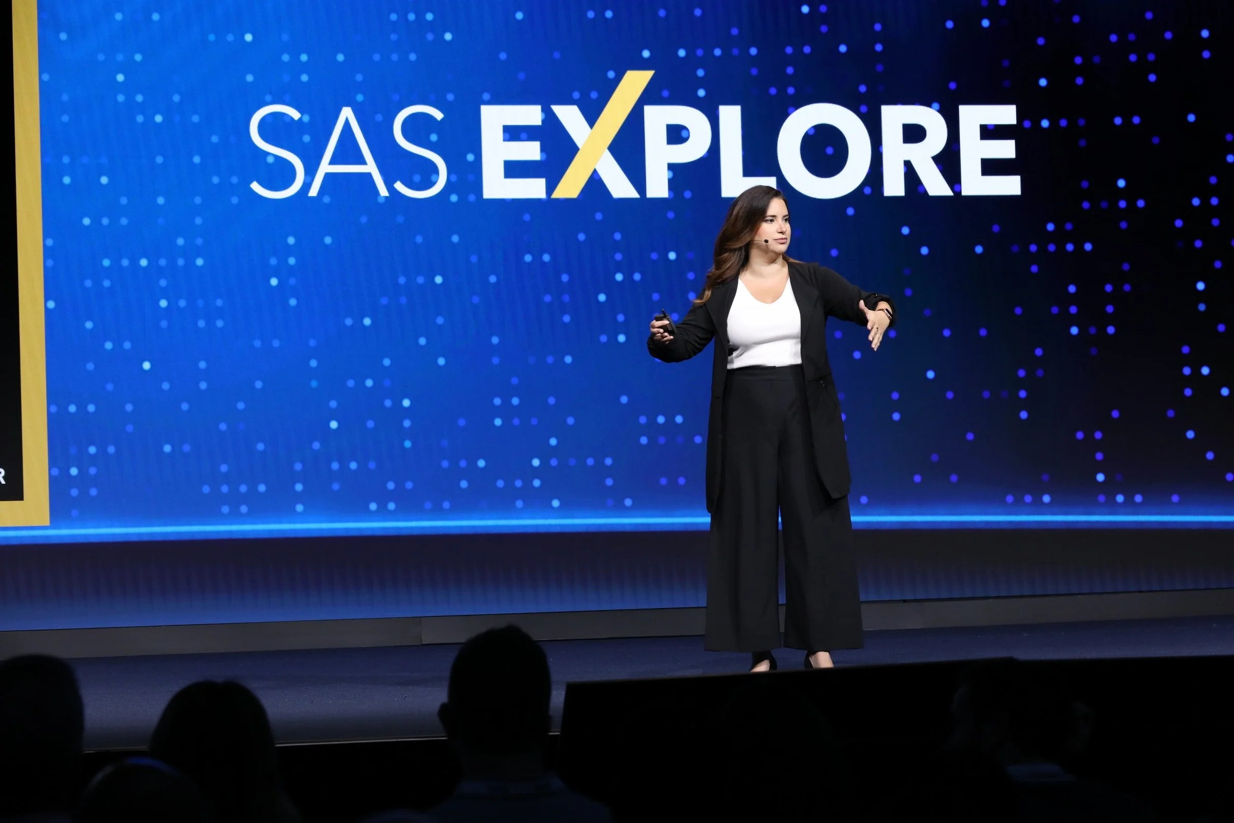 Allie K. Miller speaking on a conference stage under a large SAS Explore screen