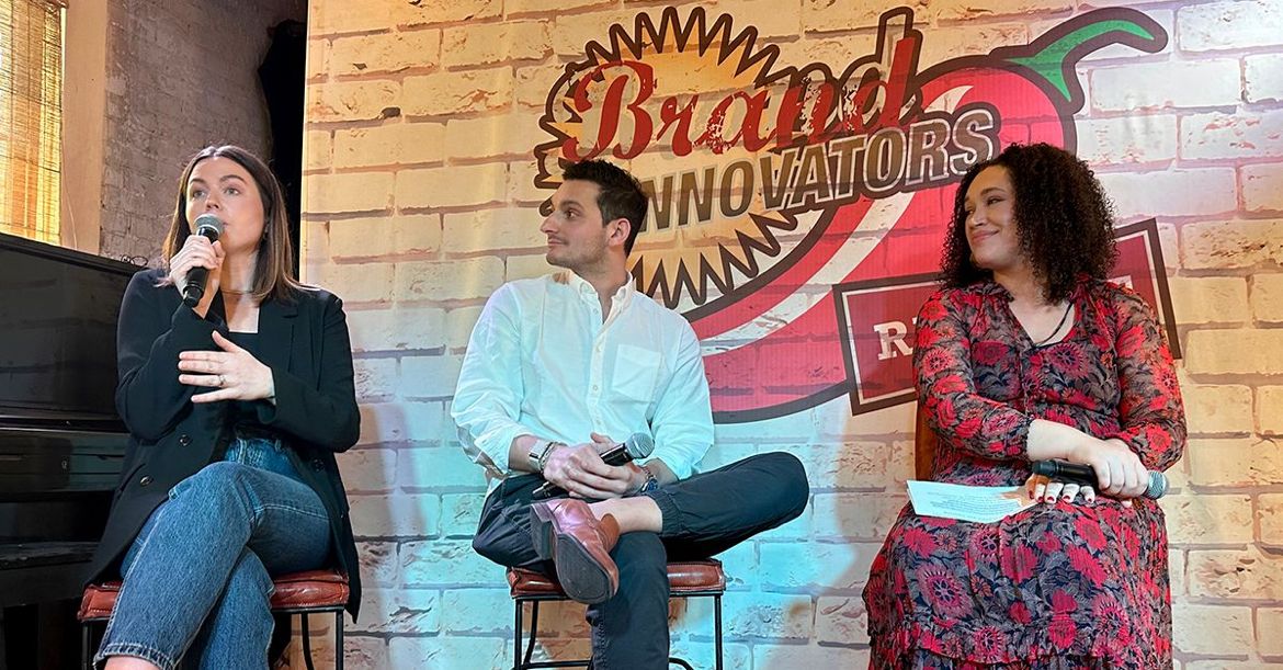 Allison Day Byrne speaking on a Brand Innovators panel, seated beside Matt Klein and a moderator.