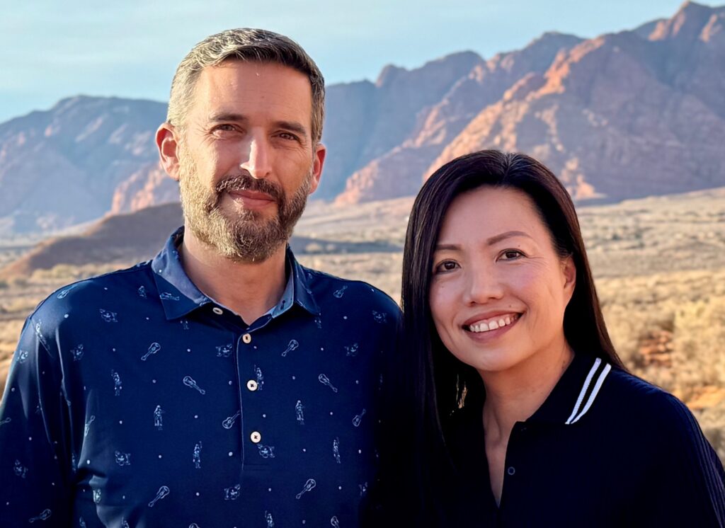 HR Pals co-founders Rob Shneer and Jamie Yang outdoors with mountains behind them