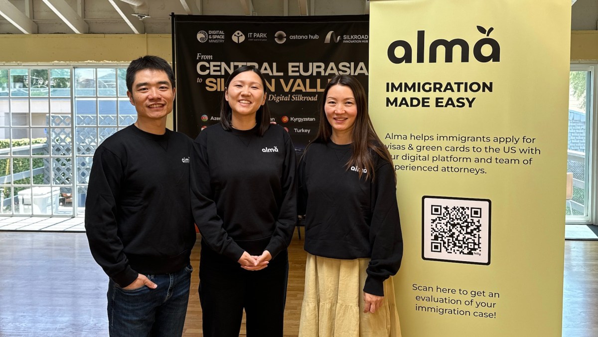 Alma co-founders at a Central Eurasia to Silicon Valley event, beside a yellow Alma immigration sign