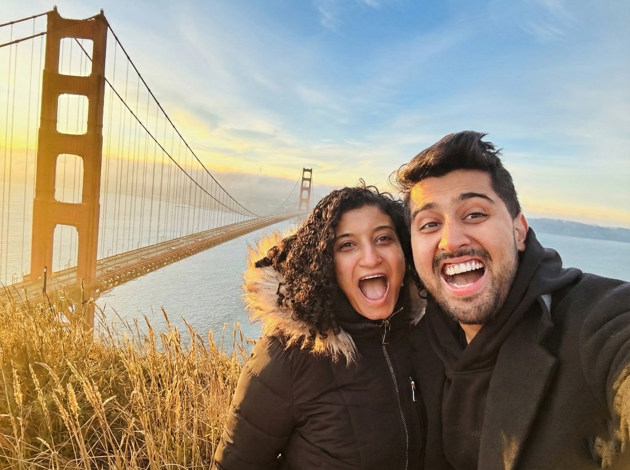Cozmo AI co-founders Nuha Hashem and Alok Kumar smiling beside the Golden Gate Bridge