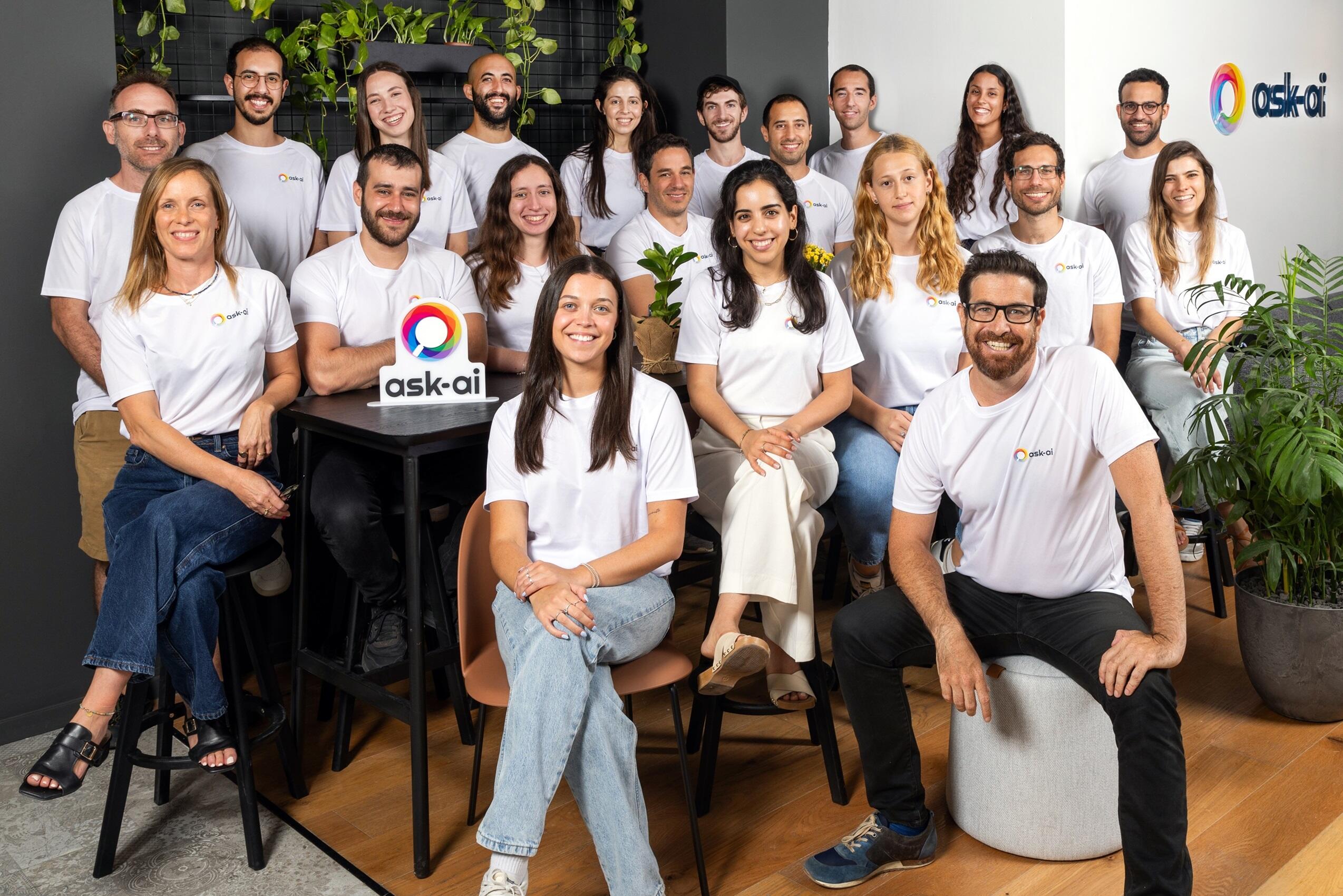 The Ask-AI team gathered around a company sign in an office, in a press photograph published in January 2024.