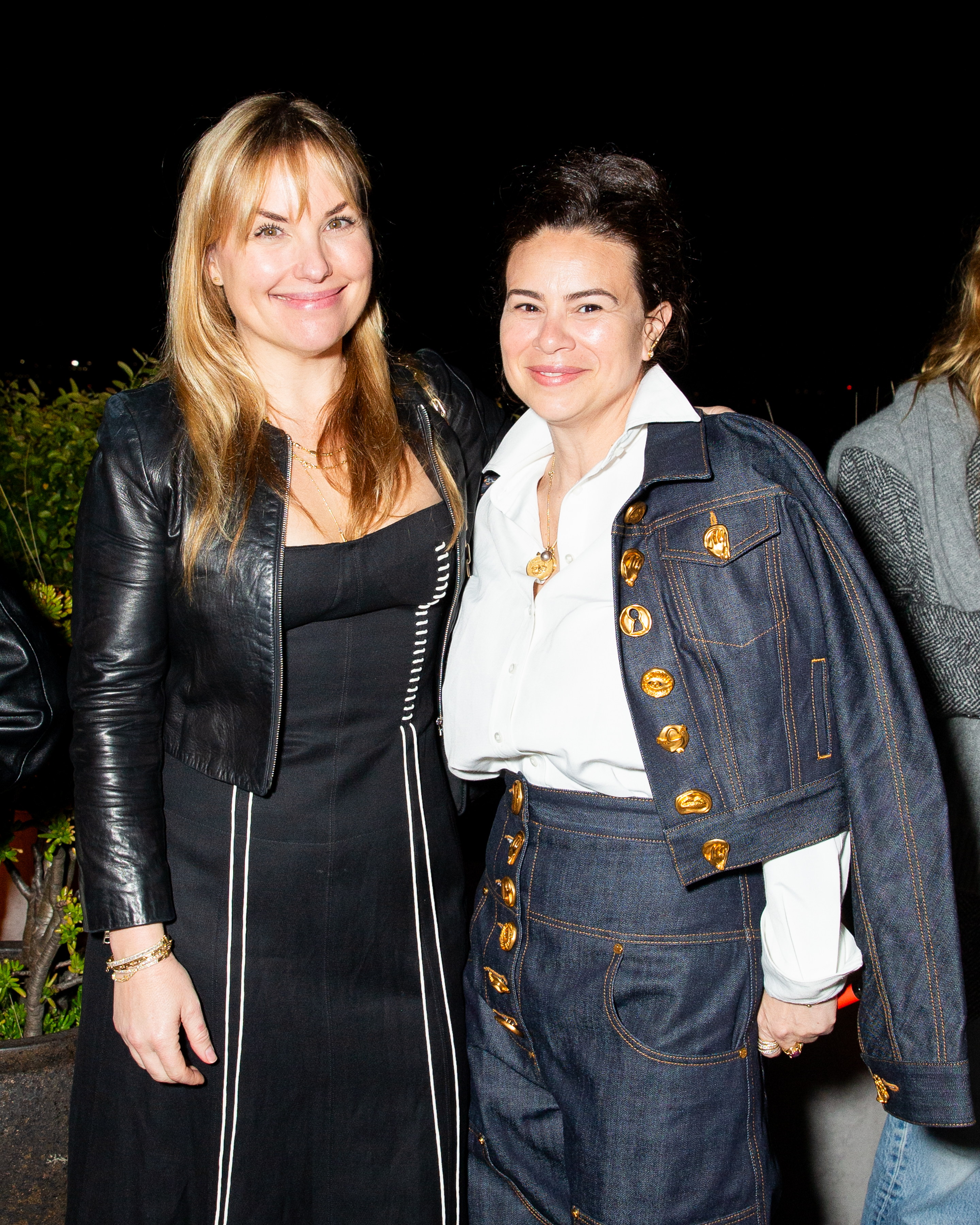 Two guests posing together at an evening event