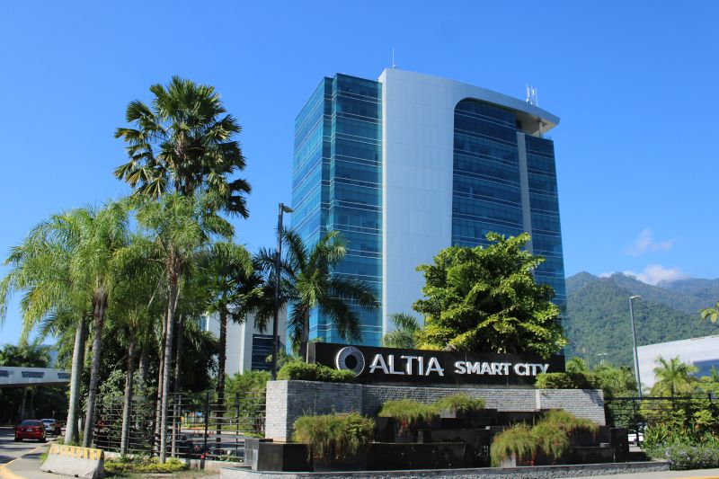 Altia Smart City office tower behind palms in San Pedro Sula