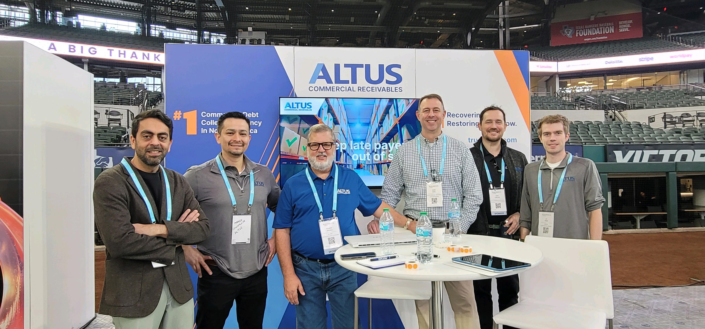 Six Altus team members at the company’s Radiance 2026 exhibition booth in a baseball stadium