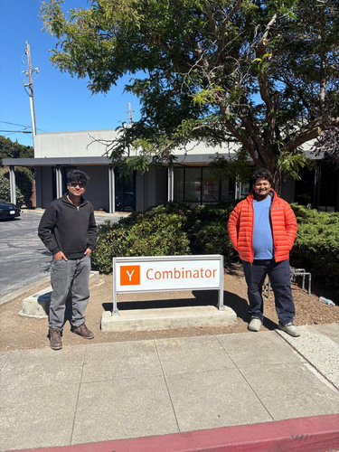 Aman Mishra and Adnan Abbas standing beside the Y Combinator sign in Mountain View