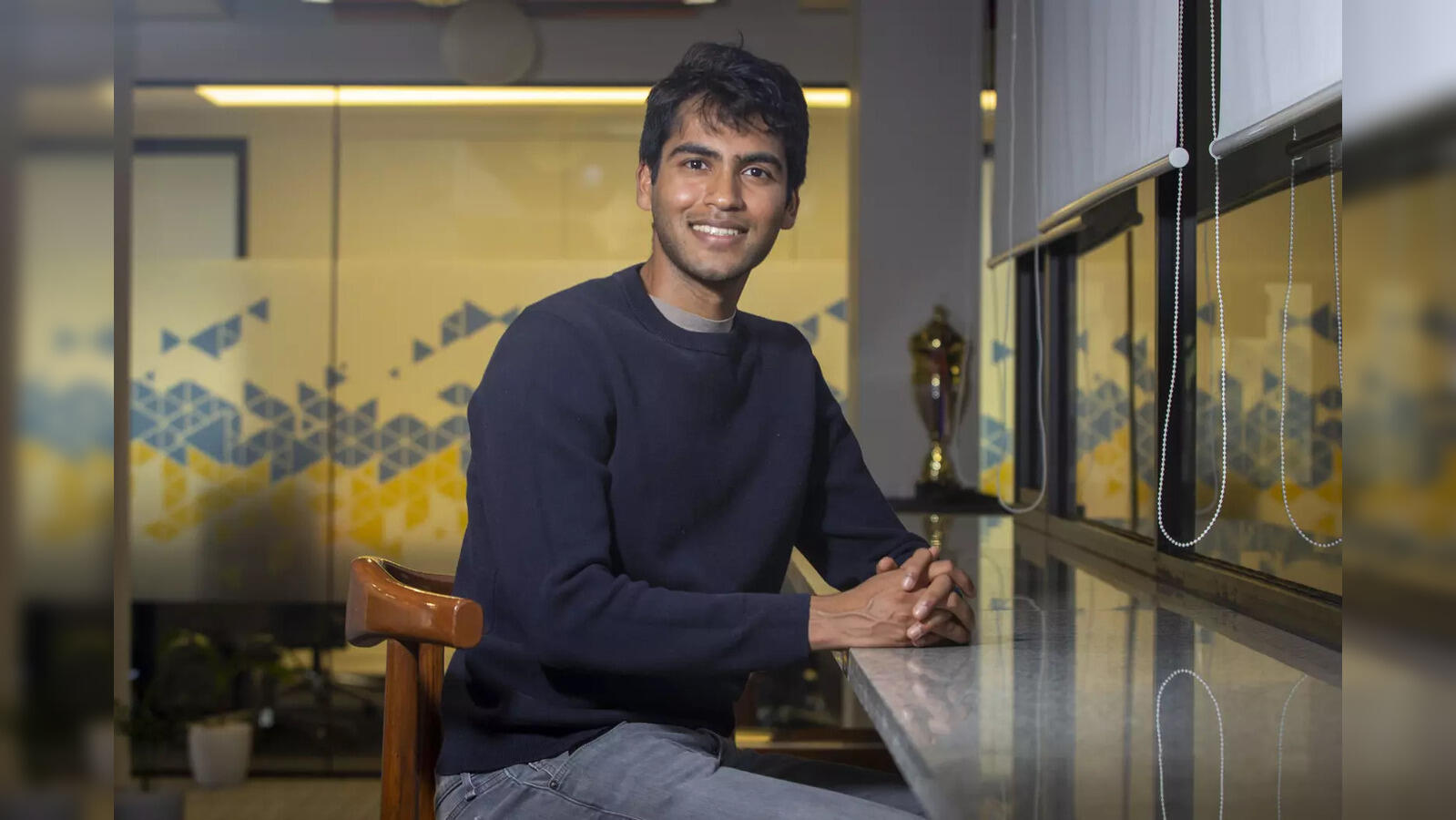 Aman Sanger seated at a desk in an office