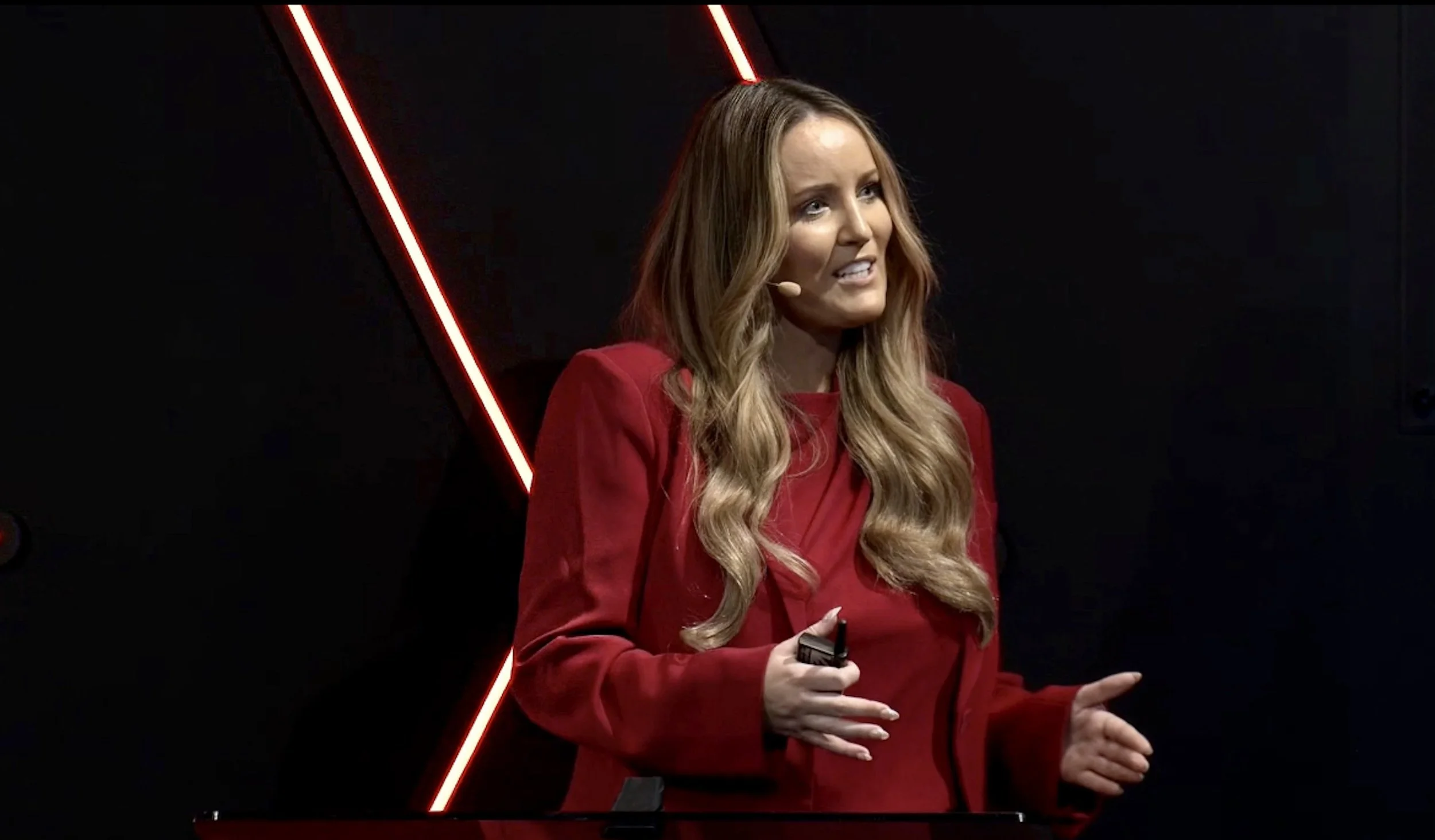 Amanda Johnstone in a red suit speaking onstage at ADMA in Sydney