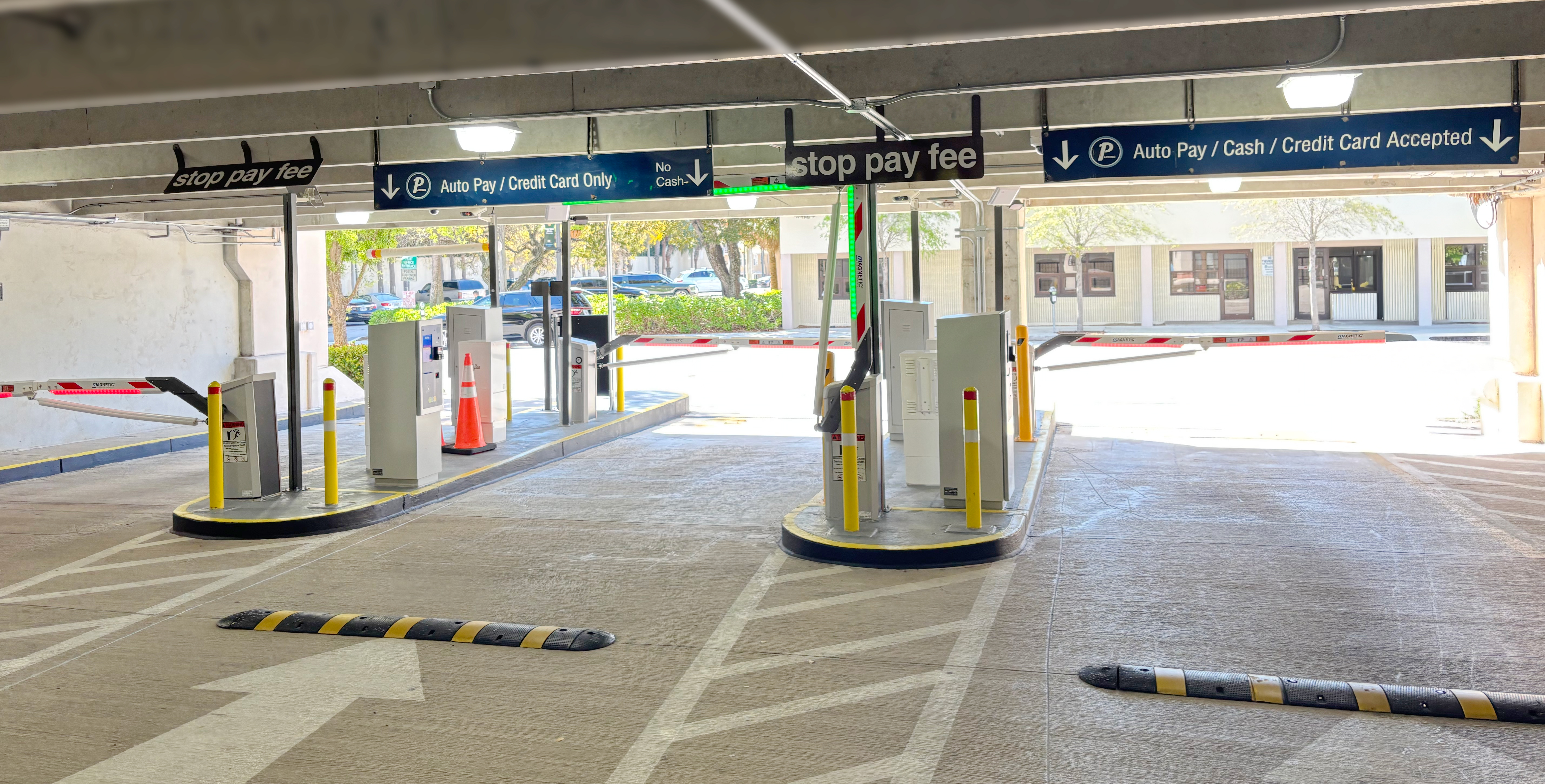 West Palm Beach garage lanes with Amano ONE equipment, overhead payment signs and barrier arms