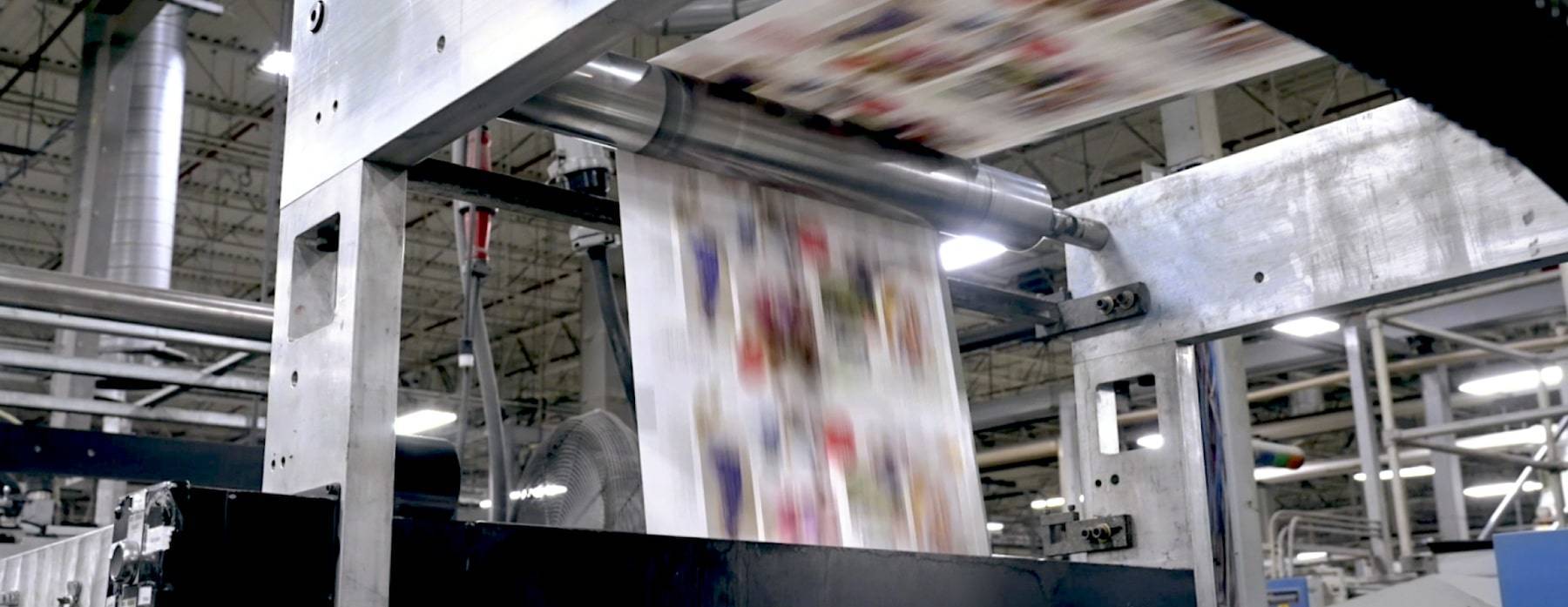 Printed paper moving through industrial equipment in the American Litho supplier case study