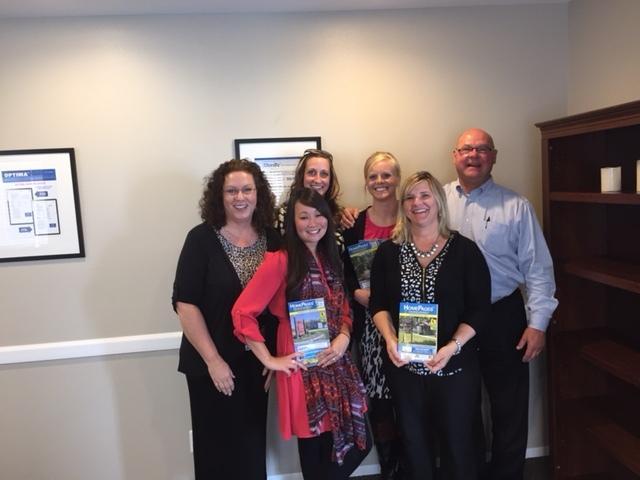 Six members of AMP’s Milwaukee team holding HomePages directories in their office