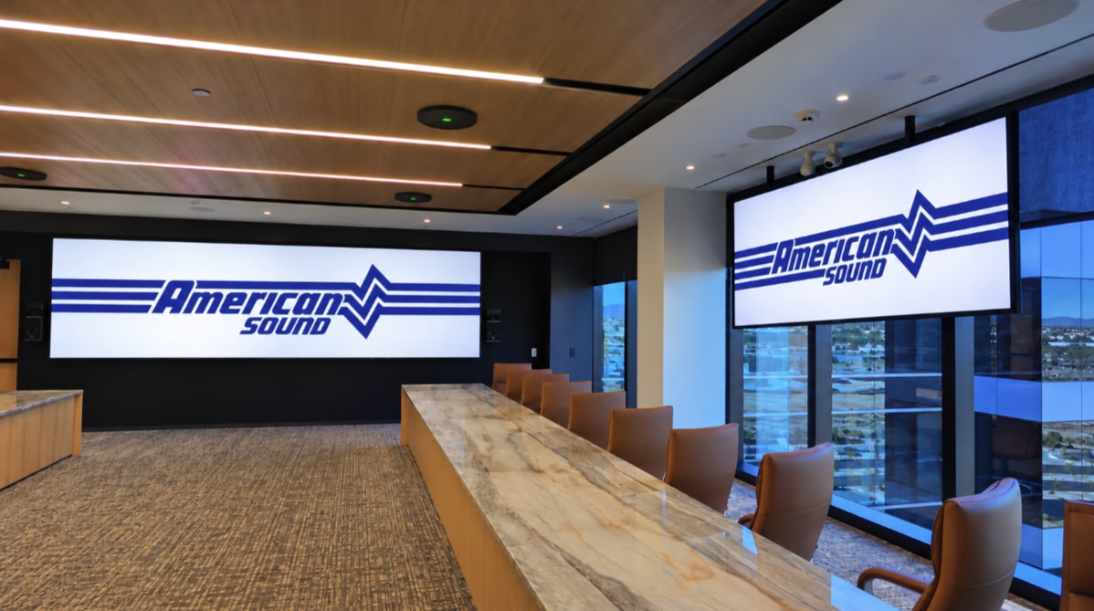 A meeting space with large wall-mounted displays and a long table at the Phoenix headquarters project