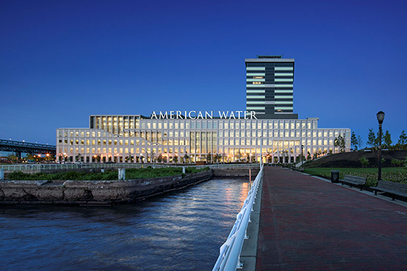 American Water’s illuminated headquarters beside the Camden waterfront at dusk