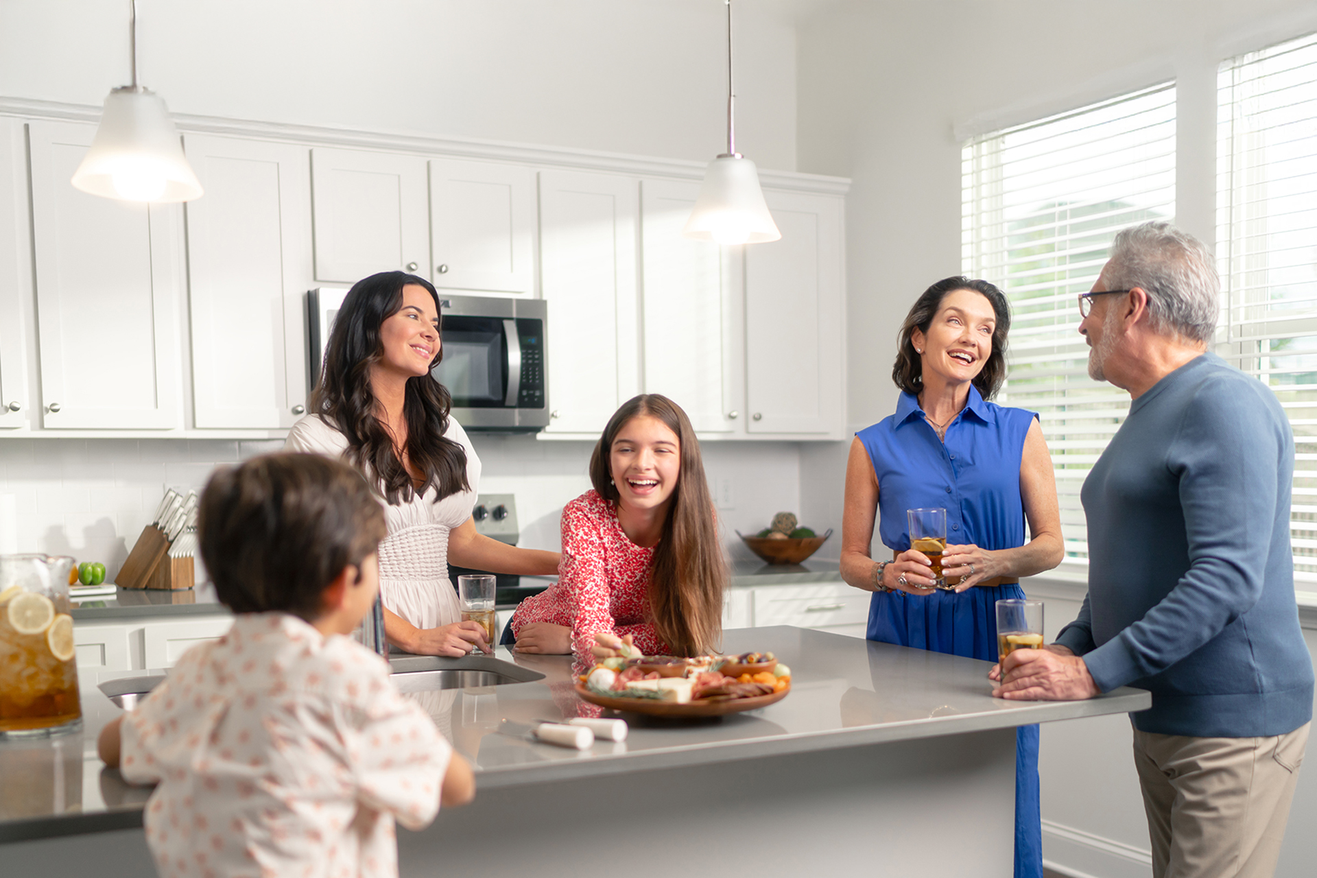 AMH lifestyle photograph of people gathered around a kitchen island
