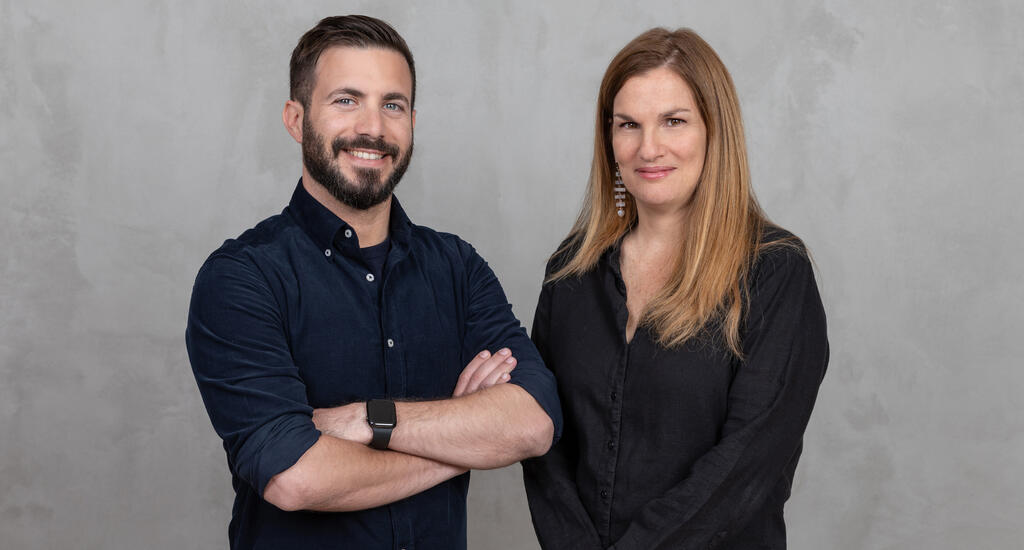 Amiad Soto standing beside Guesty president and COO Vered Raviv Schwarz