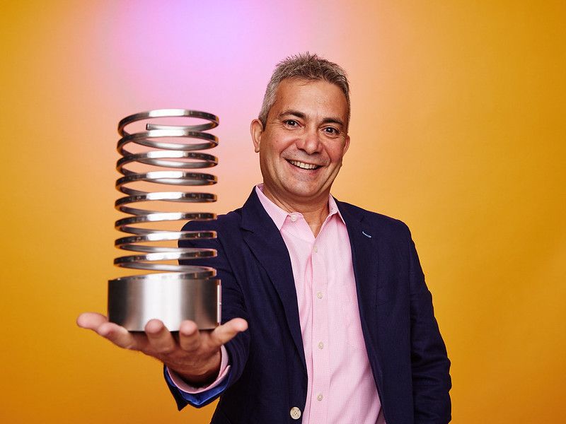 Amir Ashkenazi smiling while holding Switchboard’s Webby Award