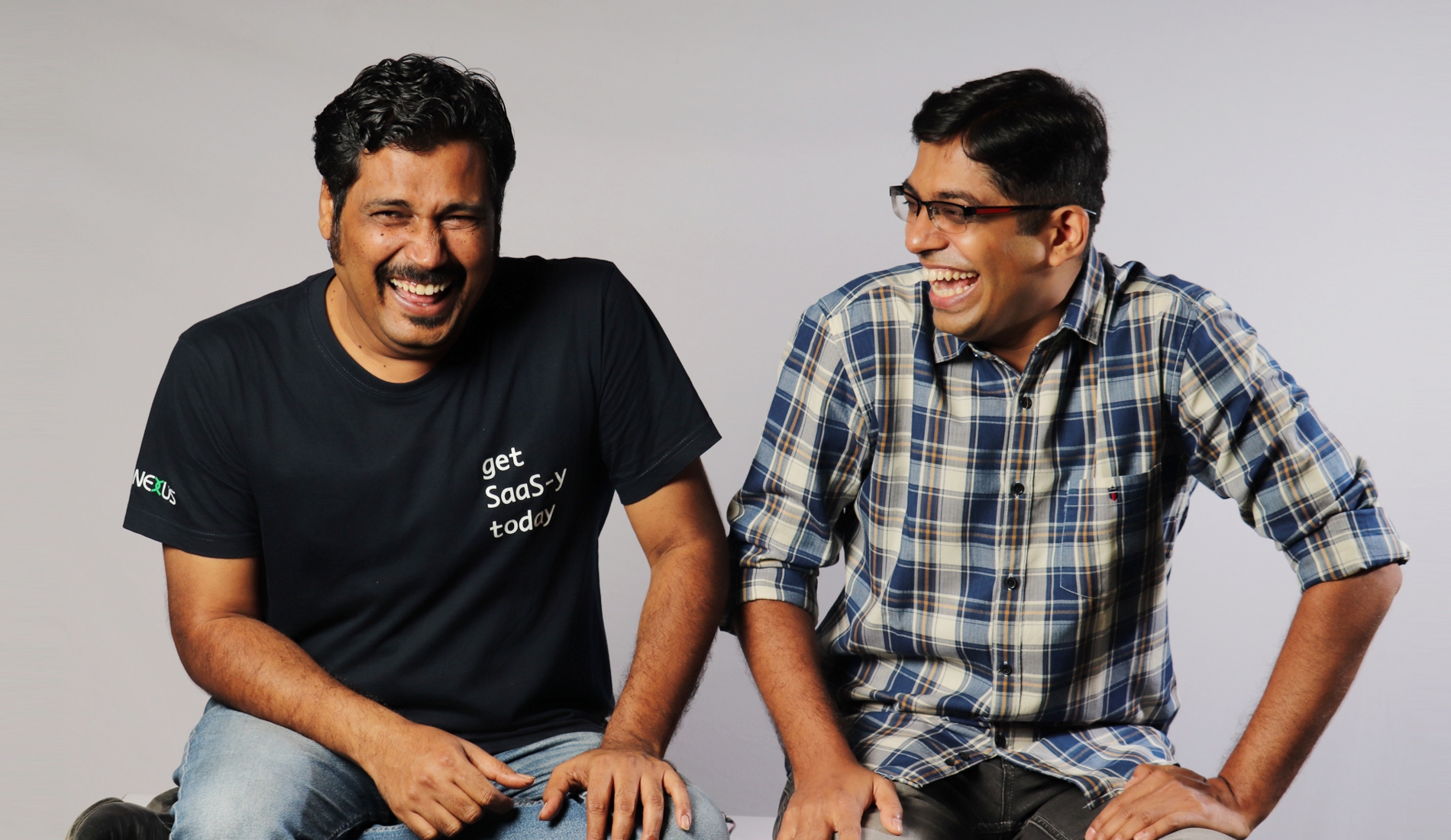 Amit Mishra, left, in a black get SaaS-y today T-shirt, laughing with iMocha co-founder Sujit Karpe