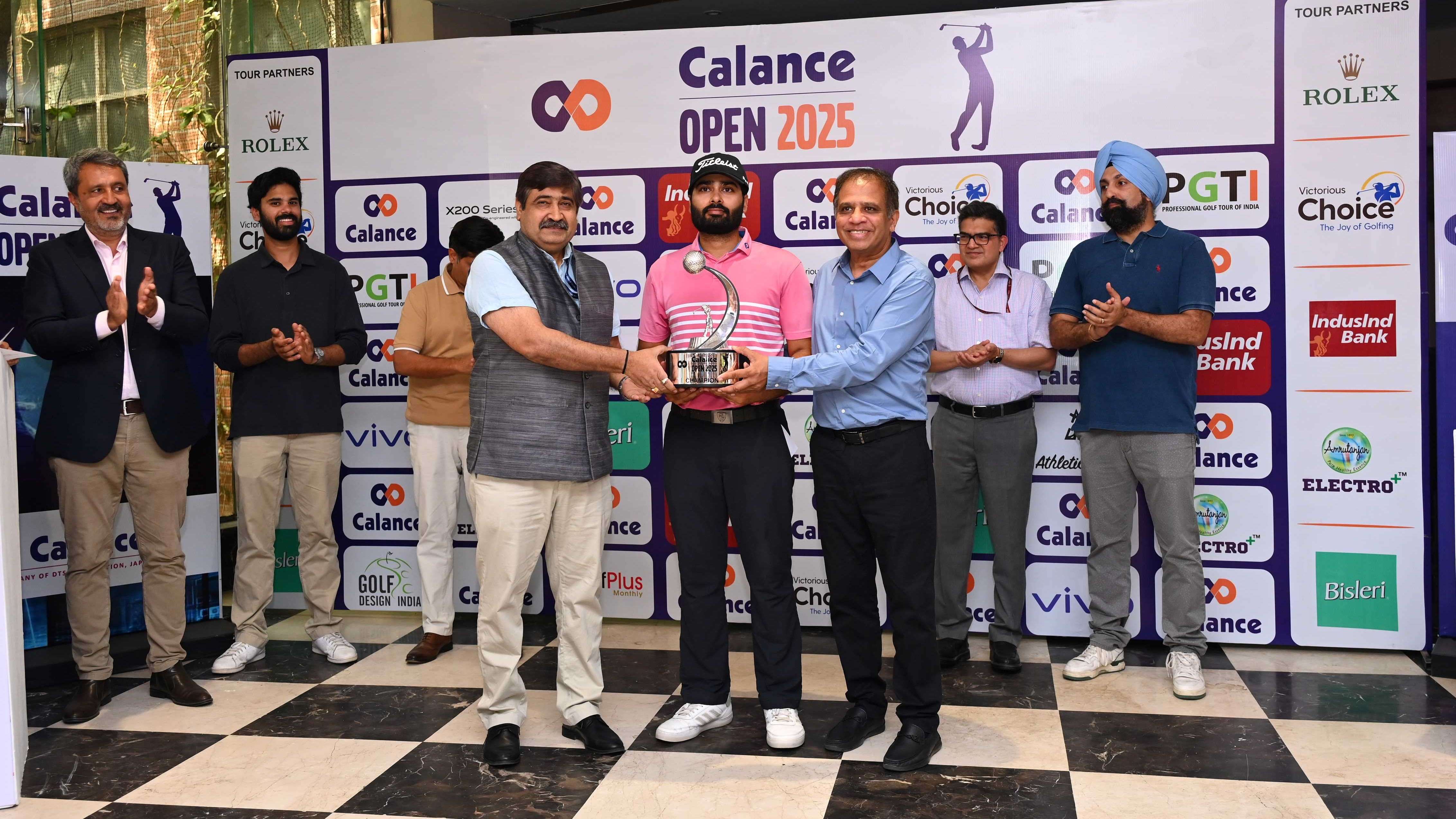 Amit Govil, in a blue shirt to the right of winner Tapendra Ghai, helps present the Calance Open trophy alongside Vijay K Singh in Delhi.
