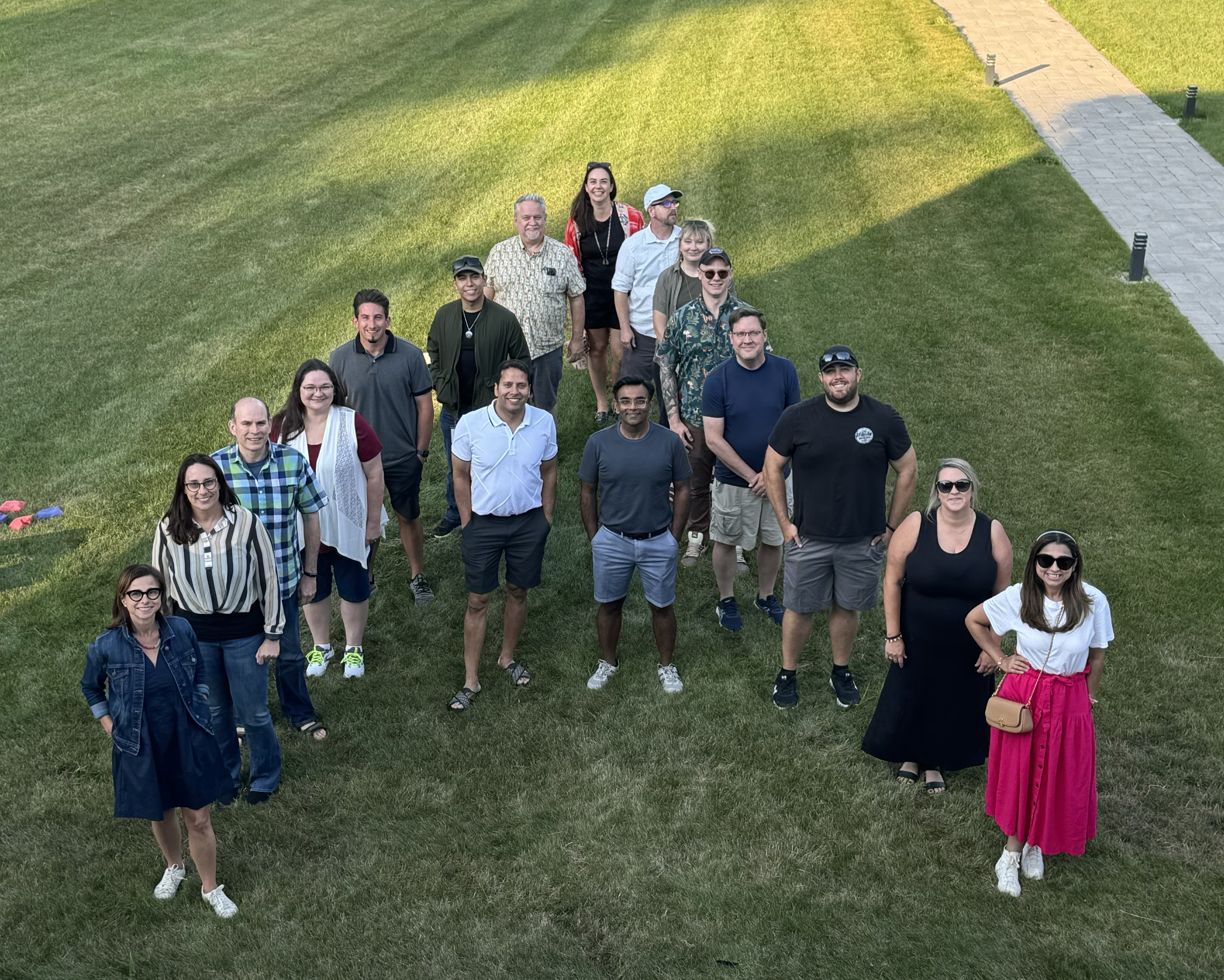 Amla employees gathered outdoors in the shape of the letter A