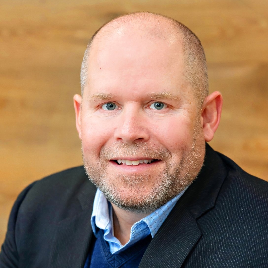 Amplix CEO Dan Gill in a blue shirt