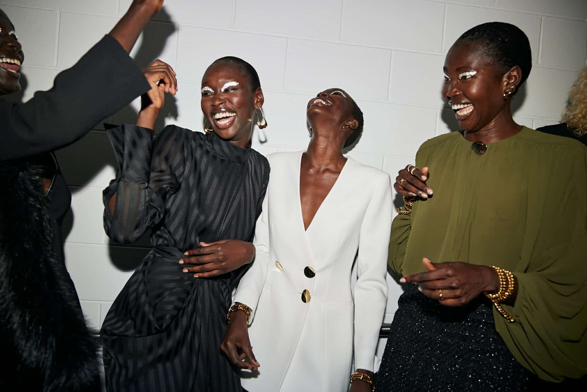 Models laughing together backstage after a fashion runway