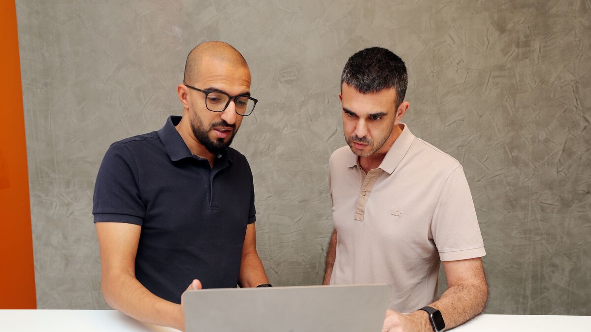 Amr Yussif and FinFlx co-founder Matthieu Capelle looking at a laptop
