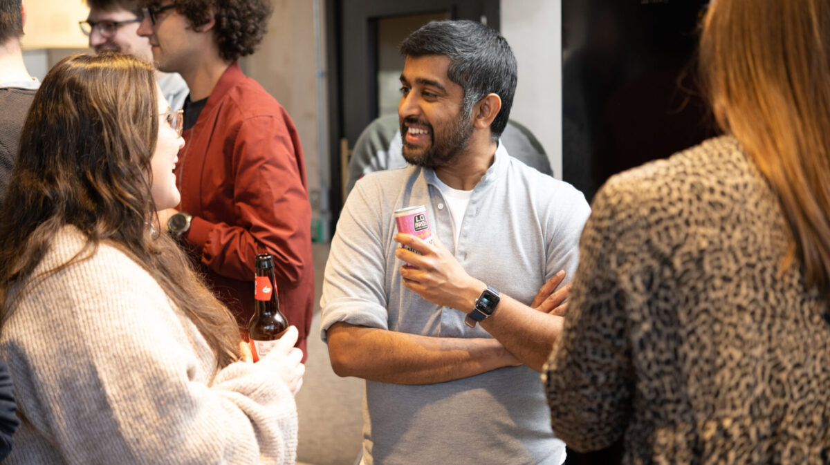 Amrit Santhirasenan smiling in conversation at a gathering