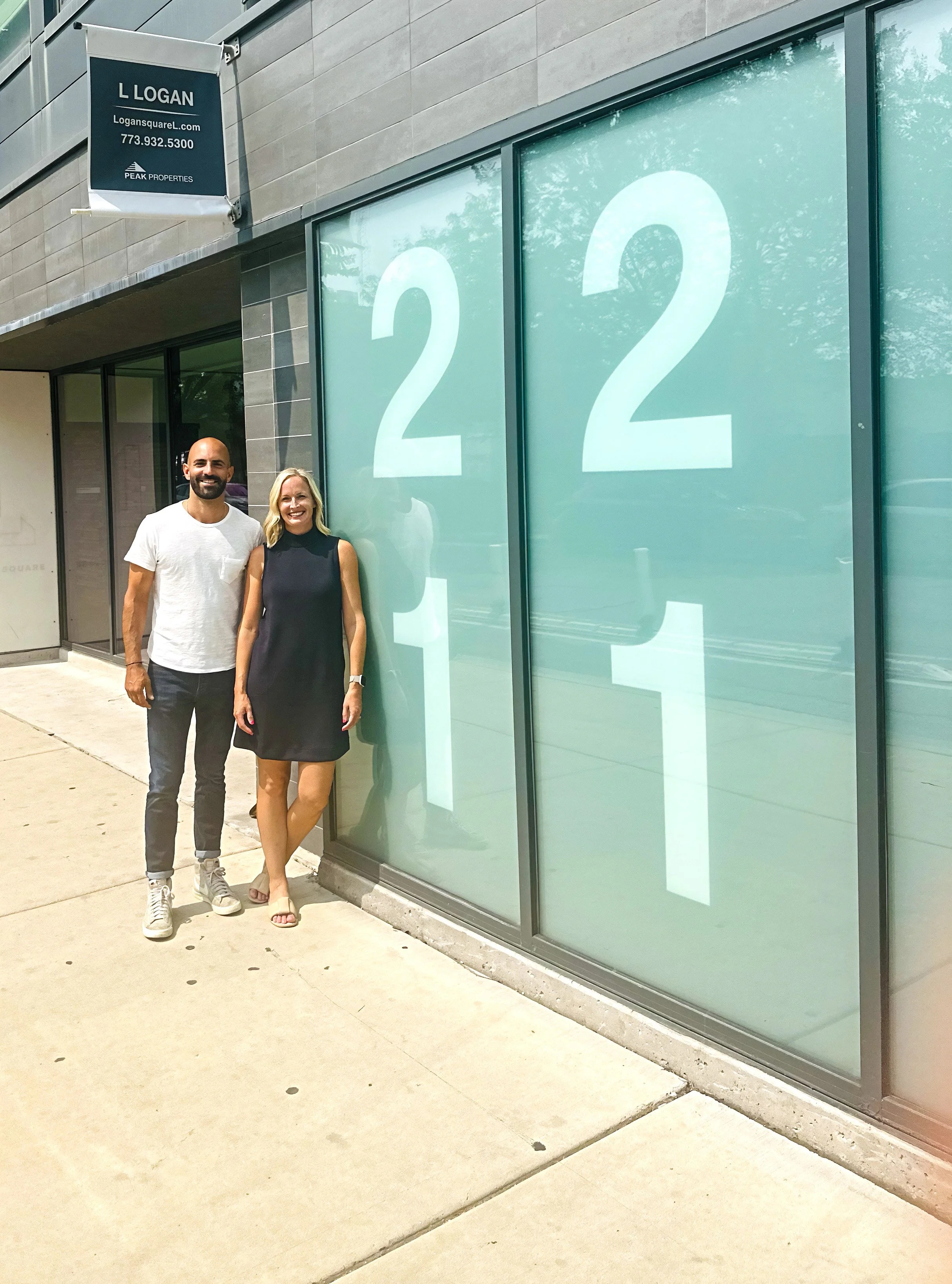Nick Nemer and Amy Johnson standing beside a window displaying the numbers 22 and 11.