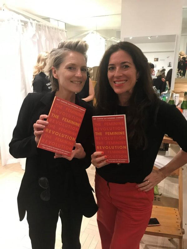 Amy Stanton, right, and another woman holding copies of The Feminine Revolution