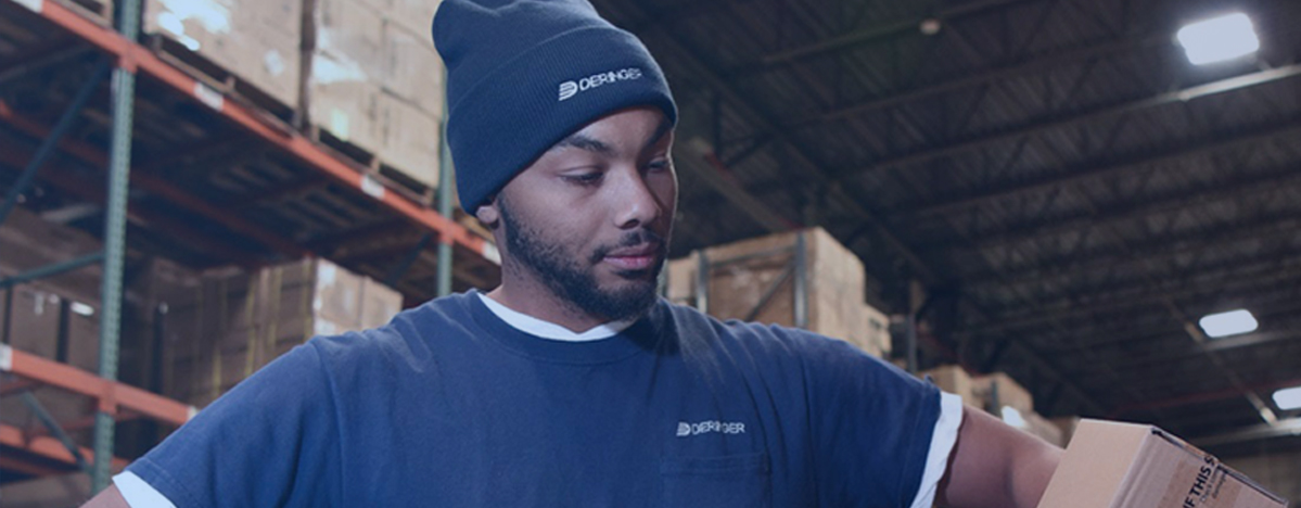 Deringer warehouse worker handling a carton in a storage facility