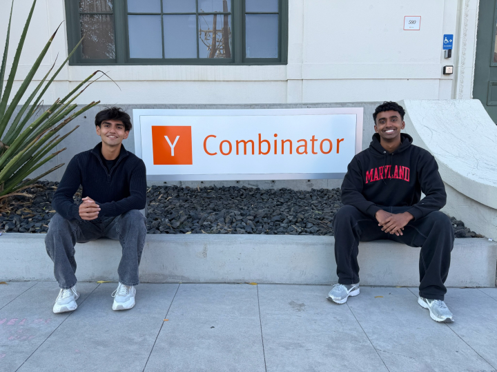 Akshay Mistry and Ananth Sankaralingam seated beside a Y Combinator sign
