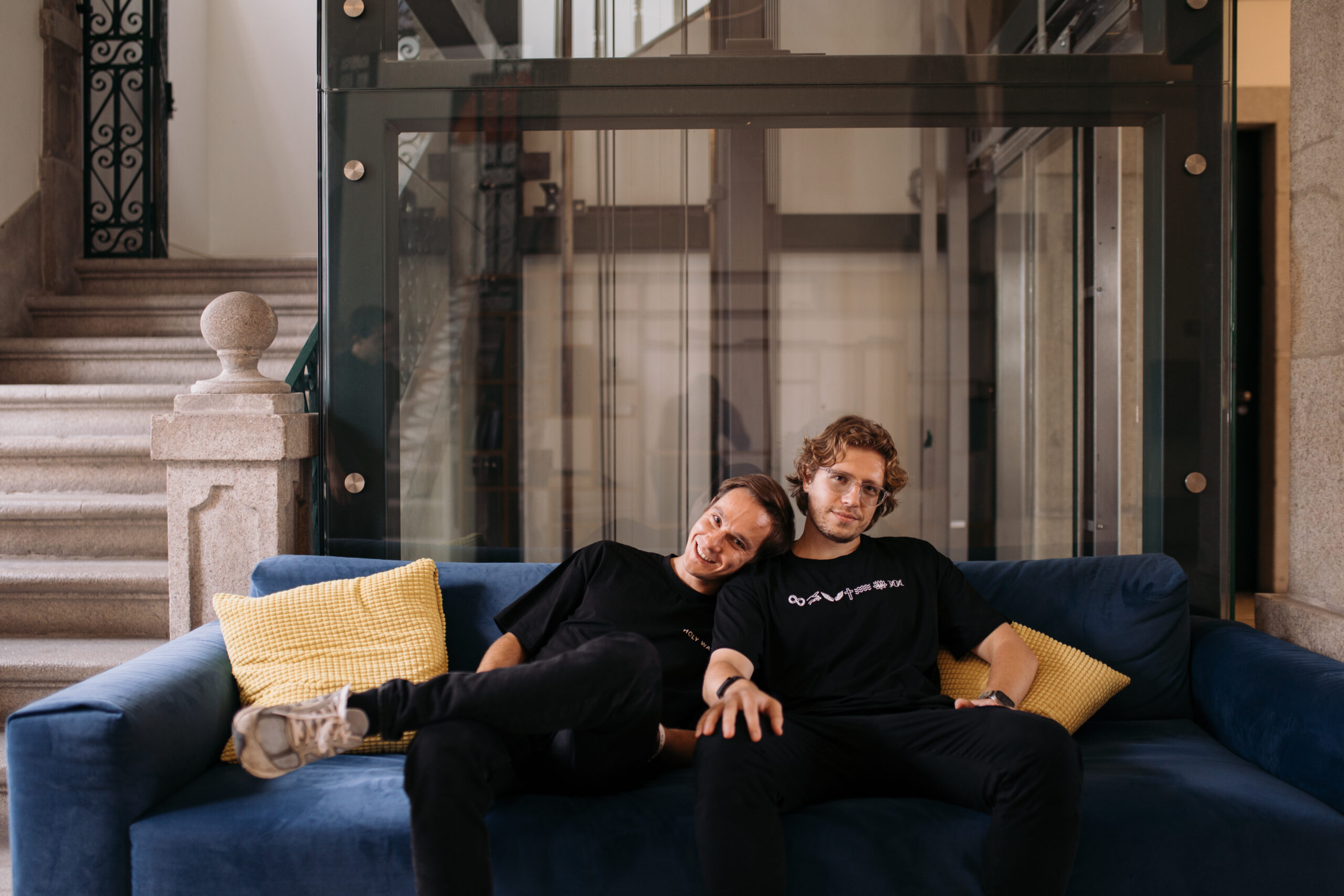 Bogdan Nesvit and Anatolii Kasianov seated together on a blue sofa