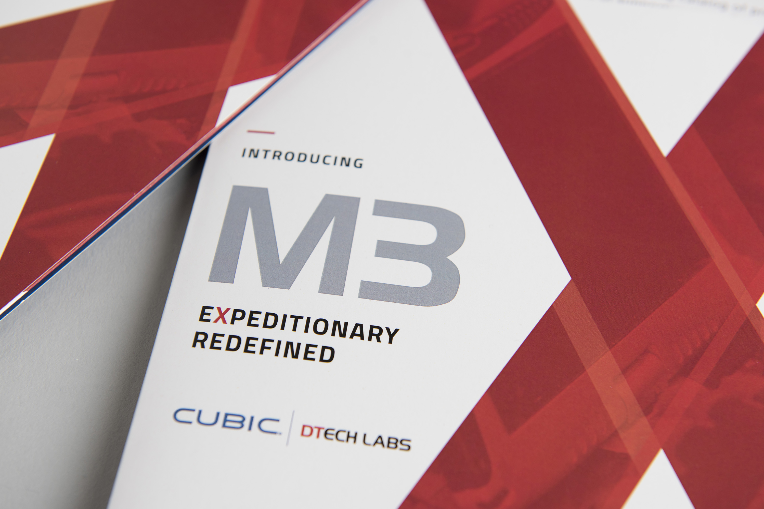 The red and white M3X launch brochure designed for Cubic DTech Labs