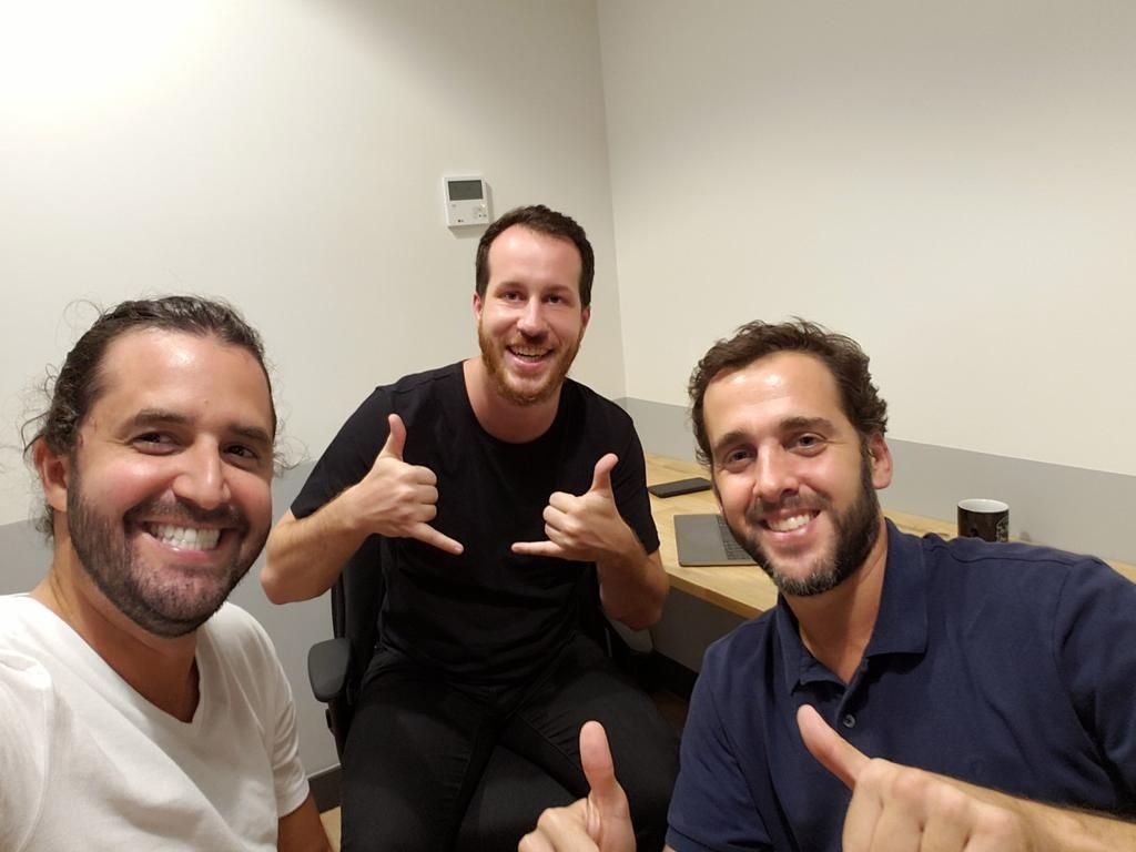 Alice’s three cofounders smiling around a table in their first shared office