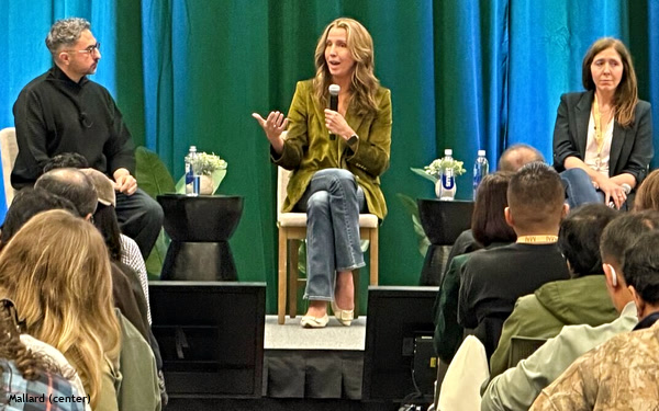 Andréa Mallard, seated at center, speaking into a microphone during a panel discussion