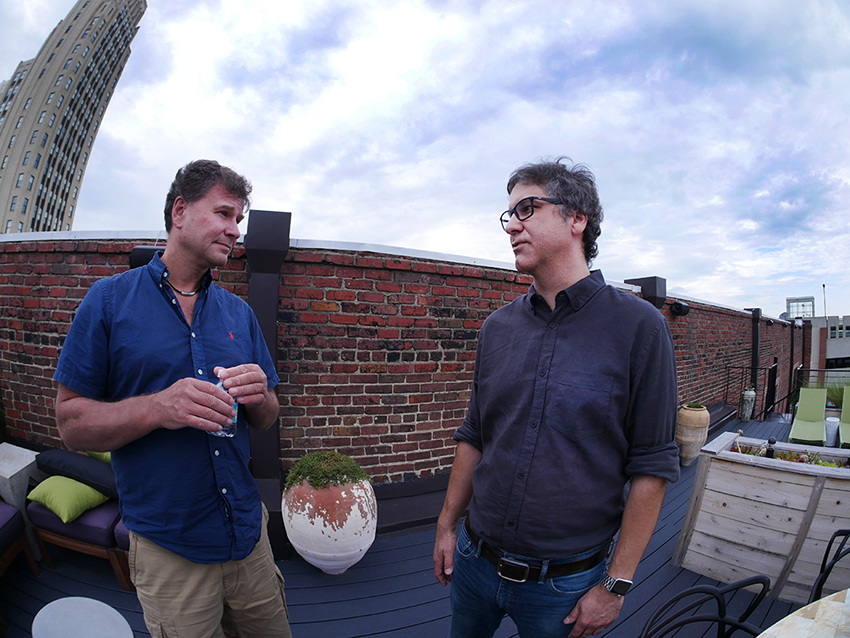 Andrei Mikheev, left, speaking with CodeVA founder Chris Dovi on a Richmond rooftop