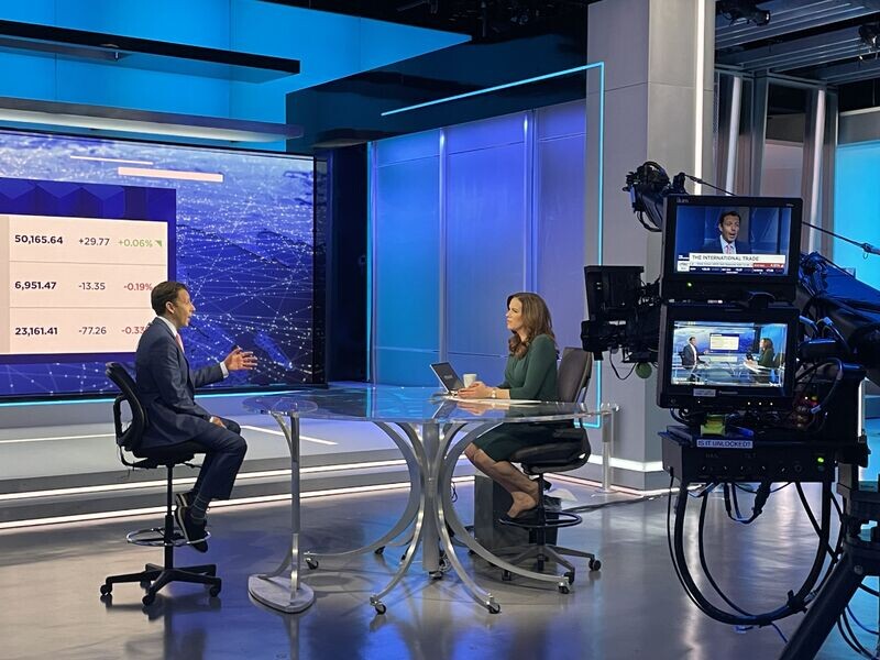 Andres Garcia-Amaya speaking with a presenter on the set of CNBC's The Exchange while studio cameras film the conversation