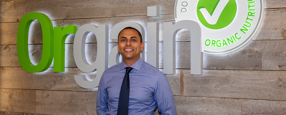 Andrew Abraham at Orgain headquarters in front of the company wordmark