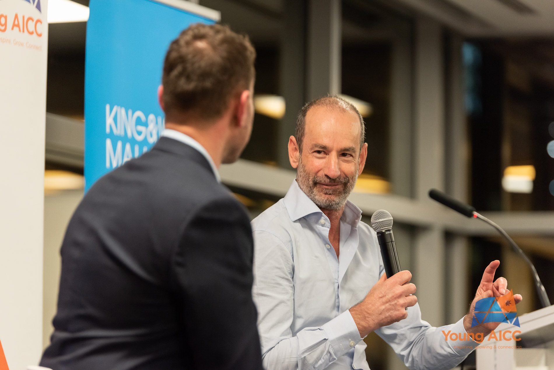 Andrew Bassat holding a microphone during a Young AICC interview in 2019