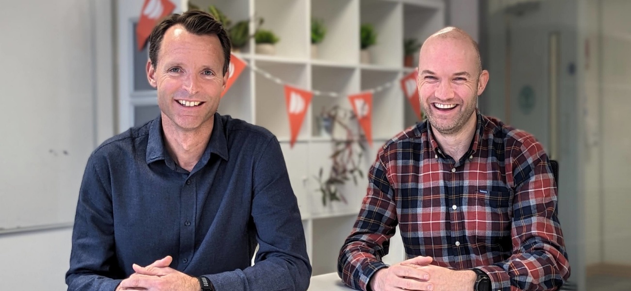 Matt Cockett on the left and Andrew Bone on the right, smiling at a table in the Dayshape office