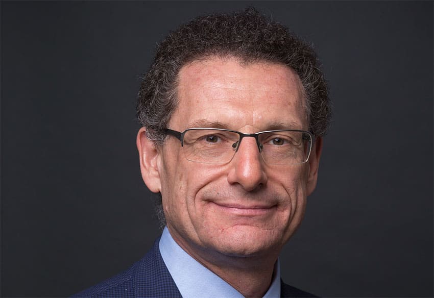 Andrew Bud wearing glasses and a jacket in a press photograph accompanying his 2019 interview