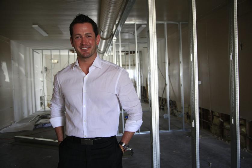 Andrew Canter in a white shirt inside an office with exposed metal framing