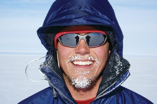 Andrew Cull outdoors in a blue hood and sunglasses, with ice on his facial hair
