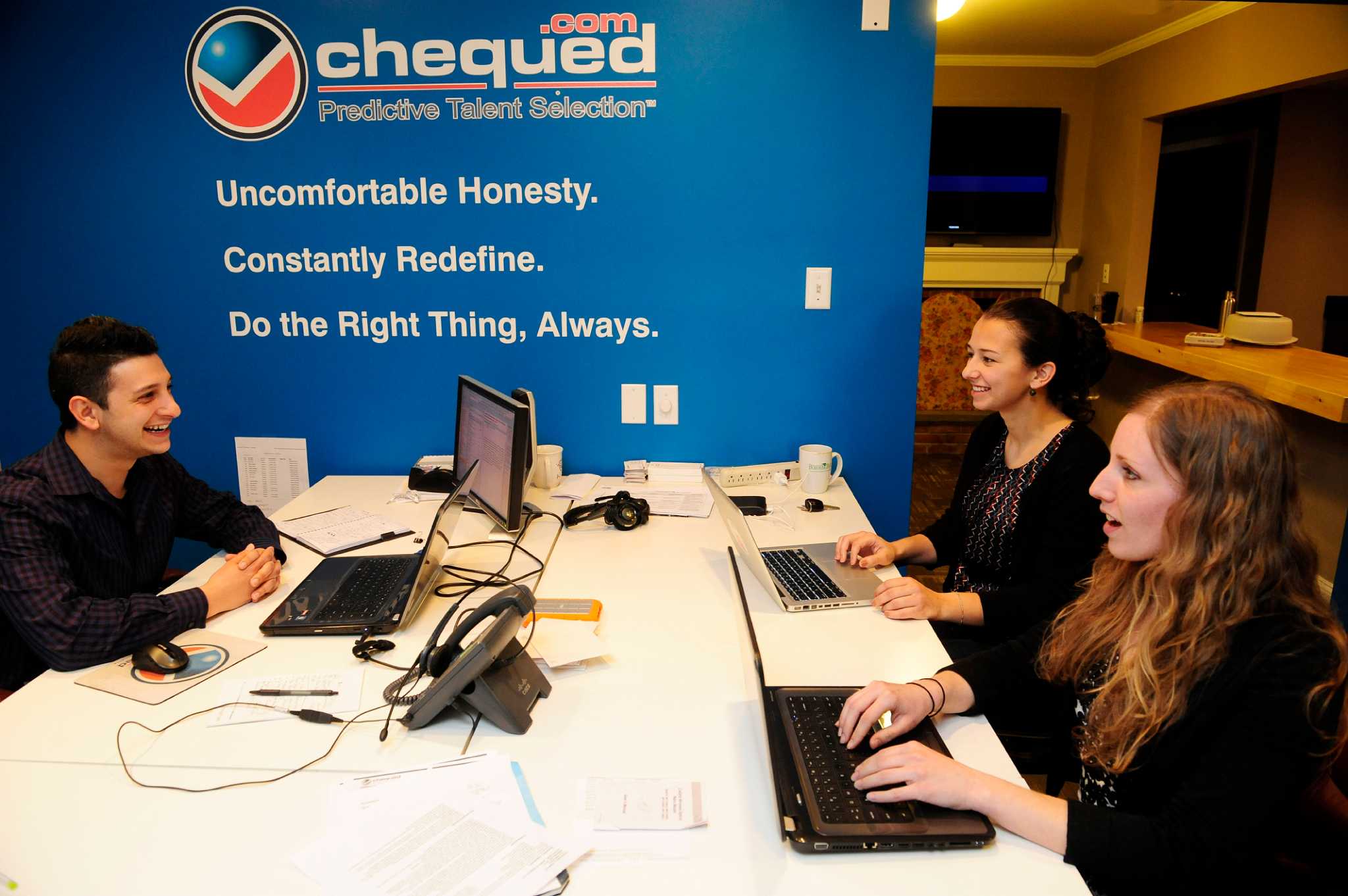 Andrew D'Agostino working at a table with University at Albany doctoral students and interns at Chequed.com in 2014